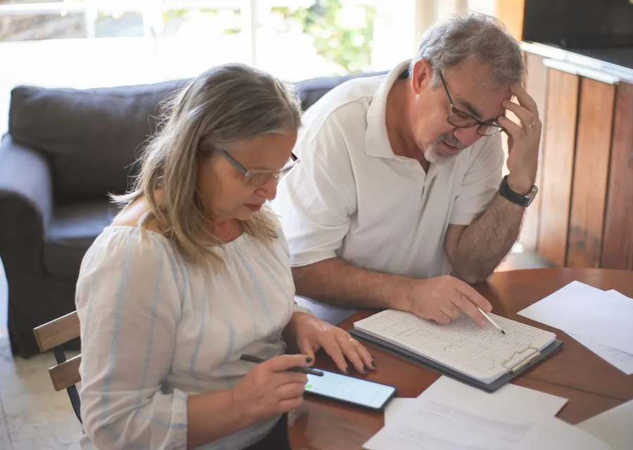 Pareja de adultos mayores revisando cuentas y documentos en casa