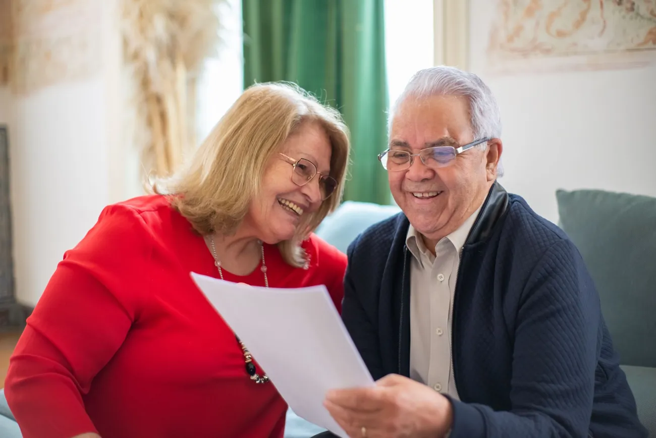 Pareja de adultos mayores revisando documentos de Medicare en casa