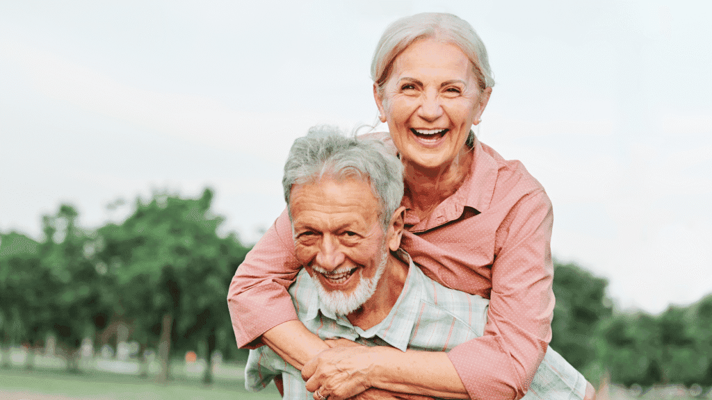 Pareja de adultos mayores sonriendo al aire libre tras comparar planes de Medicare