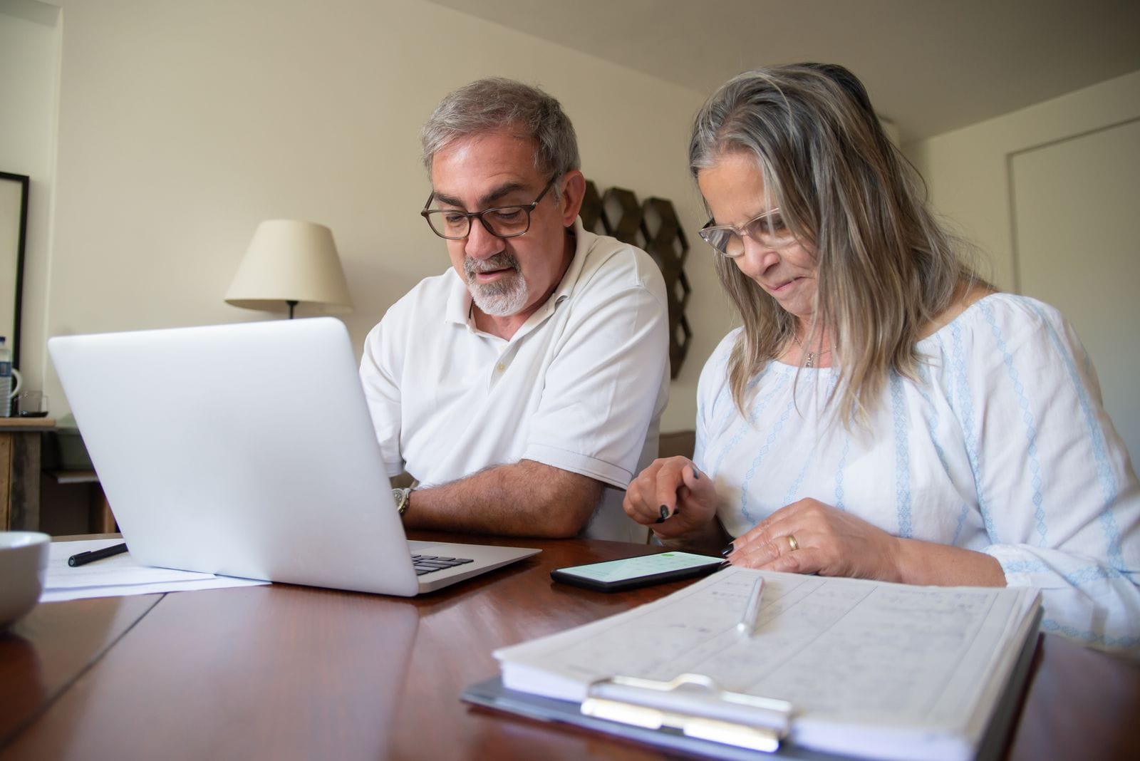 Couple reviewing paperwork and a laptop together at home
